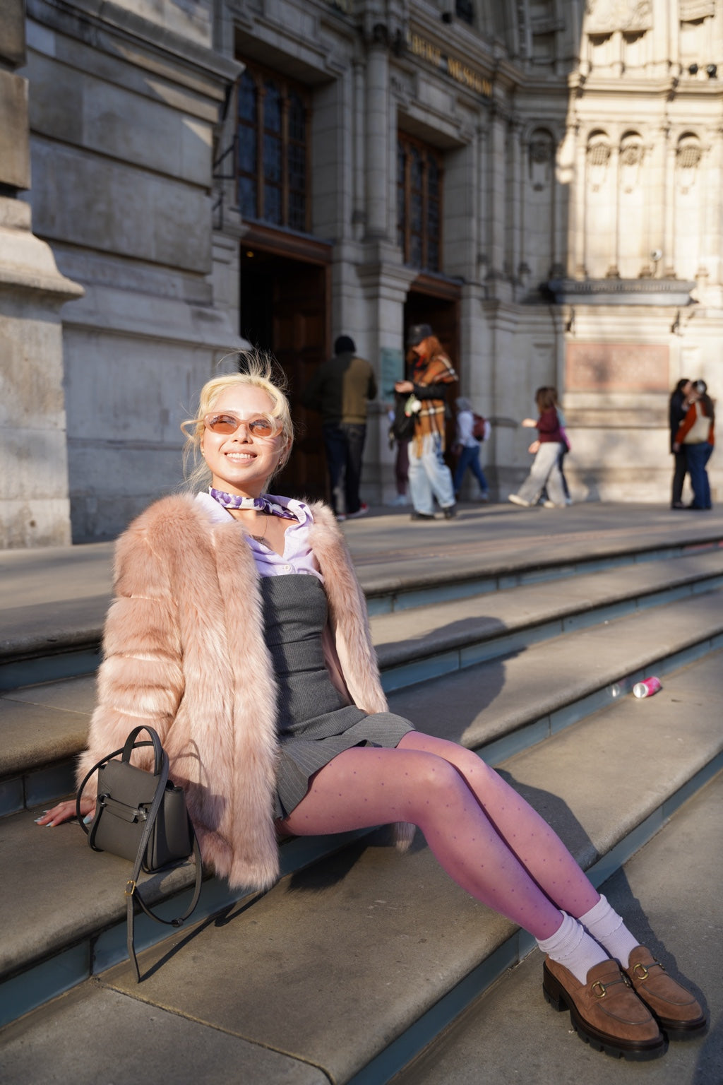 Woman styling purple Dot Drift polka dot tights on the steps of the V&A Museum