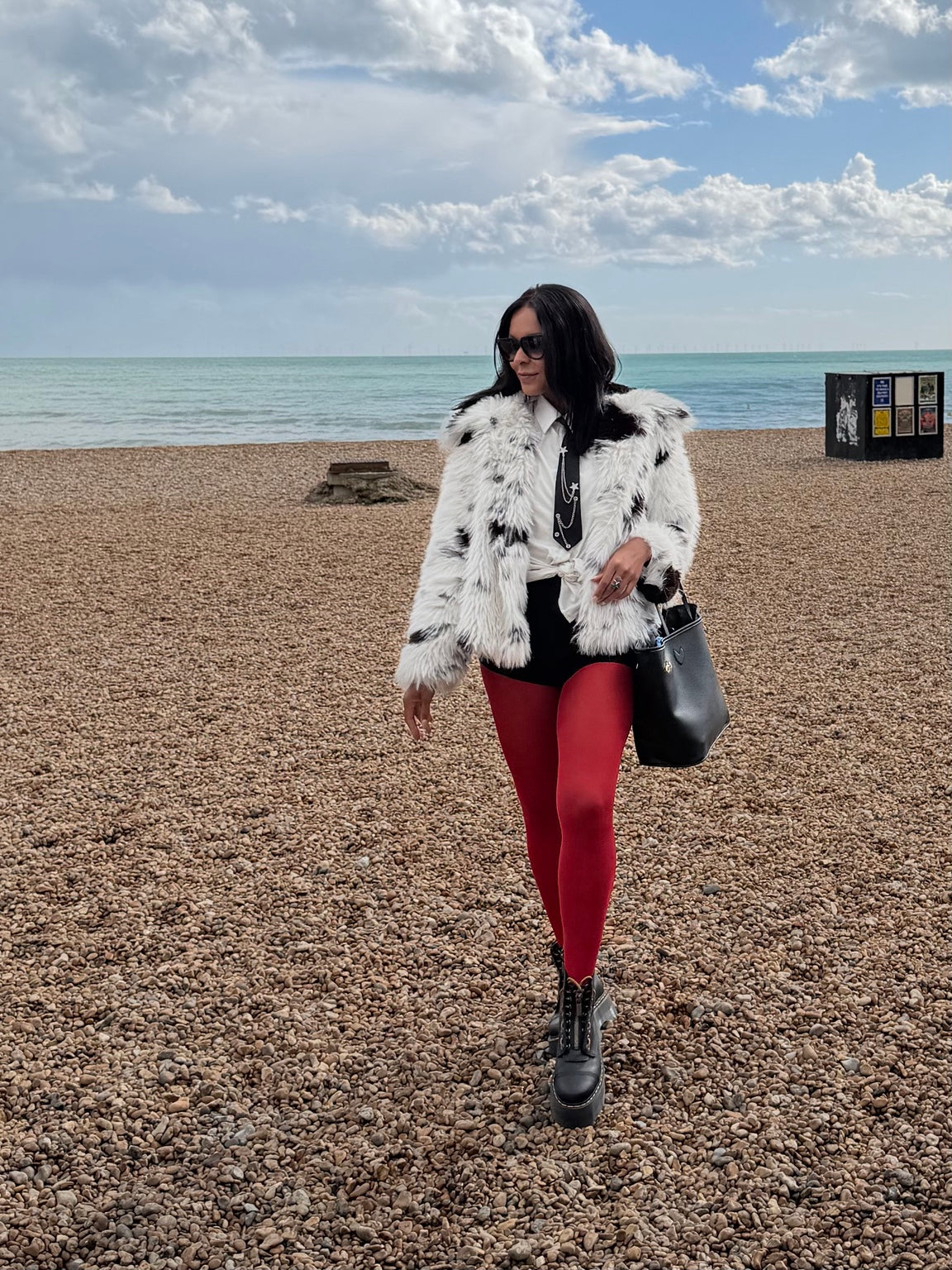 Ruby red opaque tights styled with monochrome layers and platform boots on Brighton beach
